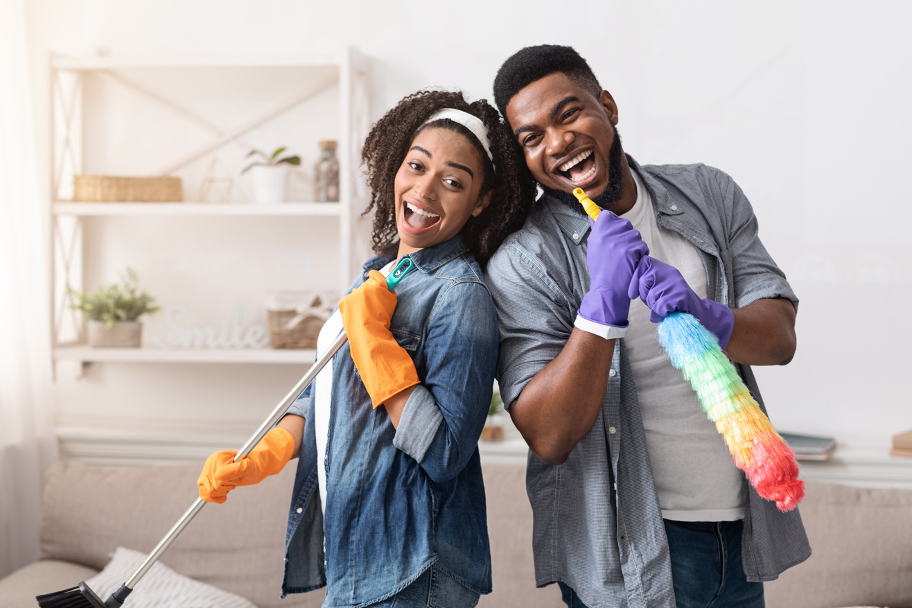 Joyful Black Couple Having Fun During Spring-Cleaning Home, Singing Together